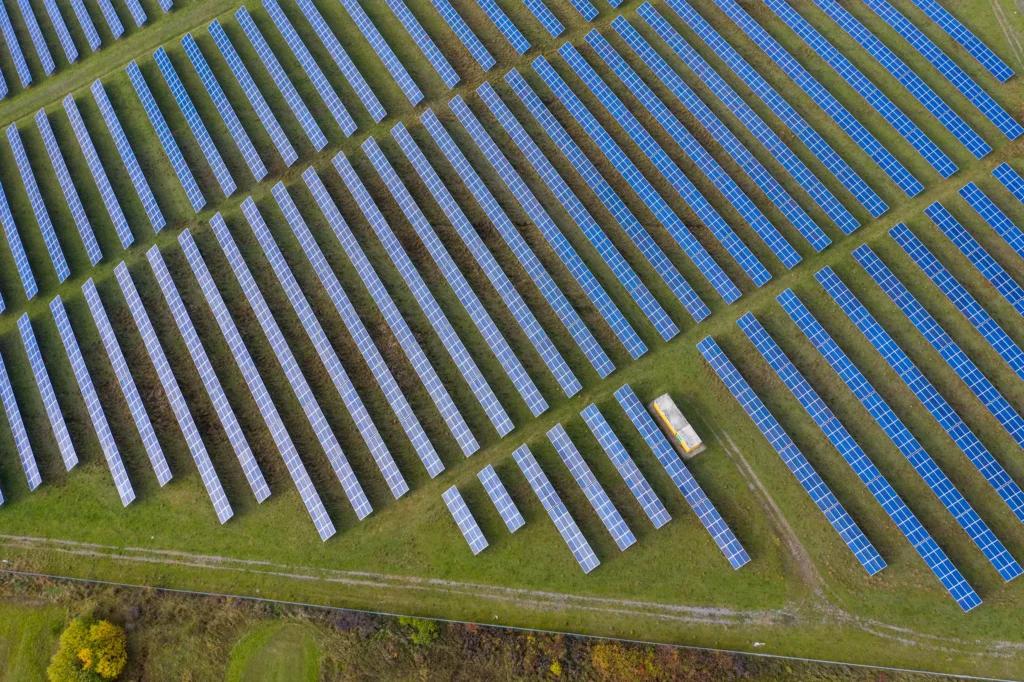 Drone image of hundreds of ground-mounted solar panel strings at a UK solar farm maintained by Roundhouse UK.