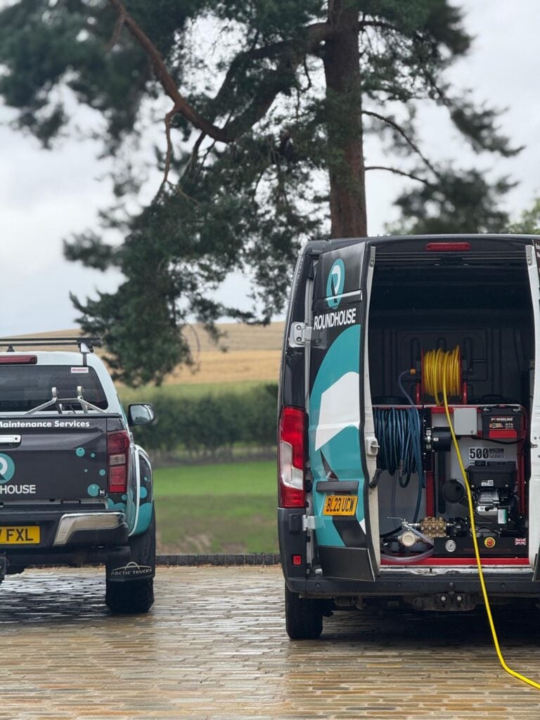Roundhouse UK branded van and truck with professional high-pressure cleaning equipment, prepared for exterior property maintenance services.