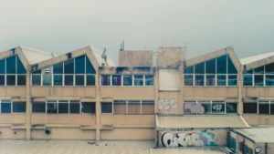 Graffiti-covered exterior of an industrial building with visible staining and weather damage.
